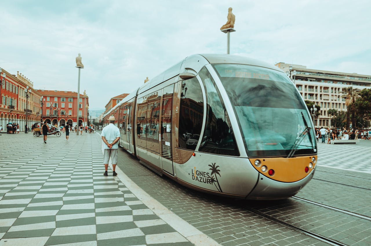 A sleek tram traveling through a bustling square in Nice, France showcasing modern urban transit.